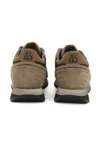 Heren bruine suède sportschoenen met een gestructureerde afwerking, een gevoerde rand en een versterkte hiel met een logo-detail. Rubberen buitenzool zichtbaar.