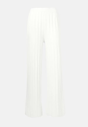 Pantalones anchos blancos con textura de relieve vertical, cintura alta y un tejido ligero y fluido. Diseñados para la comodidad y la facilidad de movimiento.