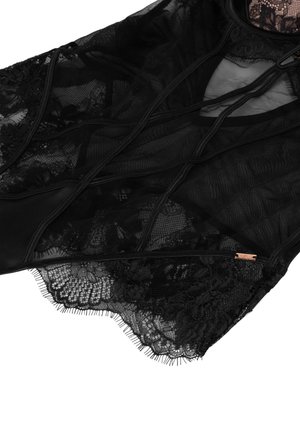 Black sheer lace garment featuring intricate floral patterns, contrasting textures, a zip closure, and delicate frayed edges.