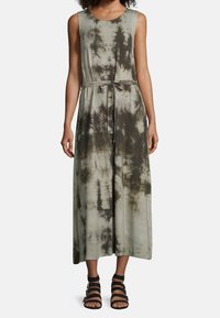Bezramionowa zielona sukienka maxi w stylu tie-dye z wciągniętym w talii krojem oraz swobodną sylwetką, uszyta z miękkiej tkaniny o gładkiej teksturze.