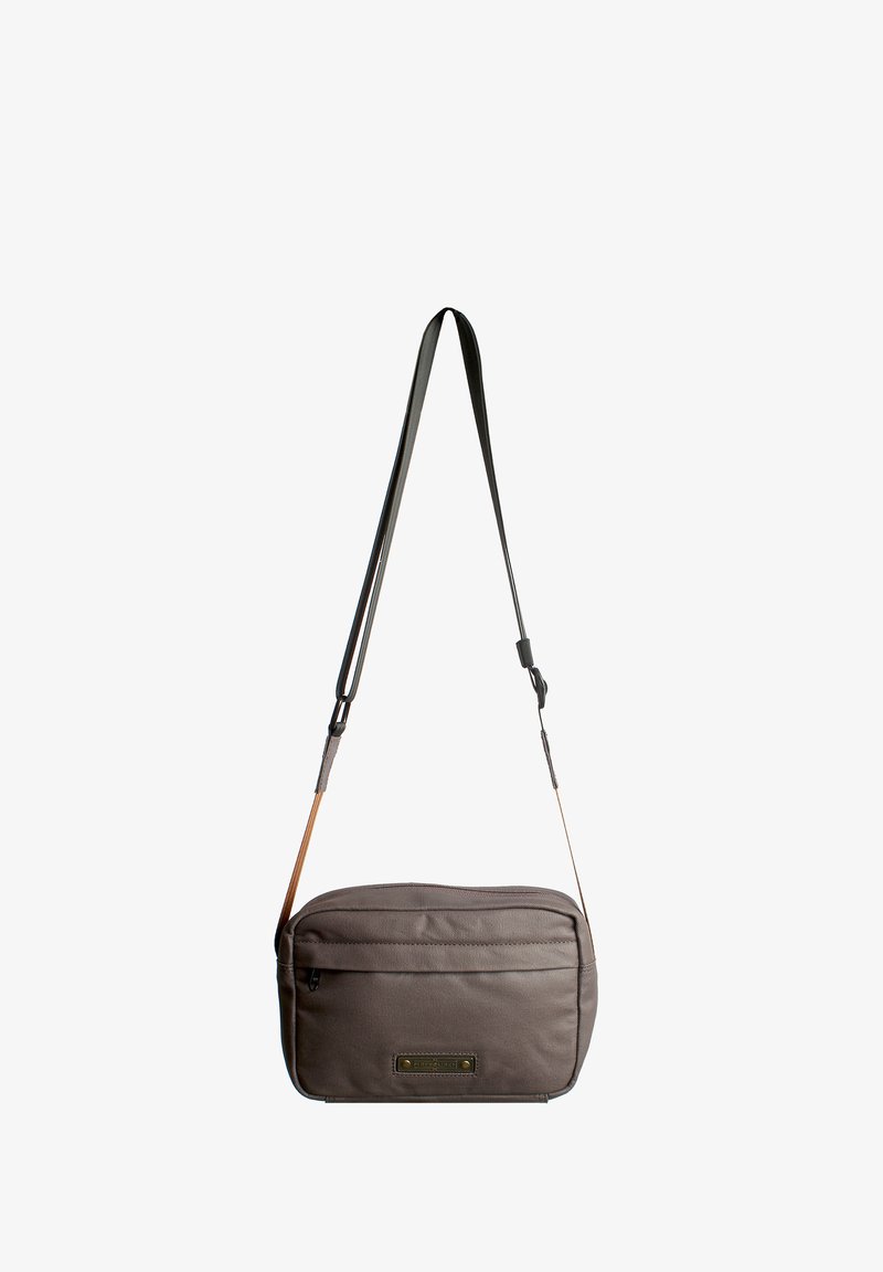 Borsa a tracolla grigia in tessuto con una texture liscia, tracolla regolabile, tasca frontale con zip e una toppa con il marchio sulla parte anteriore.