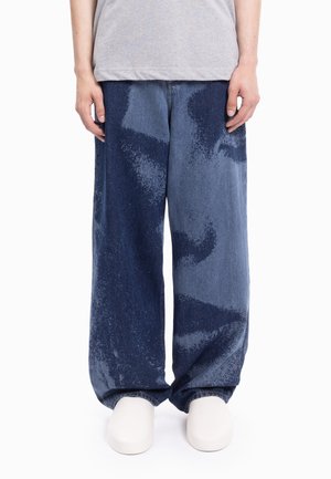 Szerokie spodnie dżinsowe o gradacyjnym niebieskim wzorze z teksturowanym motywem, wykonane z denimu, o luźnym kroju i widocznych przeszyciach.