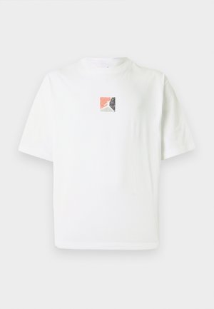 T-shirt en coton blanc à manches courtes avec un petit motif carré en corail, noir et gris au centre.