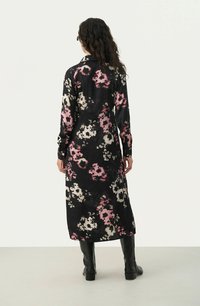 Rochie lungă neagră cu modele florale colorate în roz, crem și gri. Țesătură netedă, cu mâneci lungi și guler.