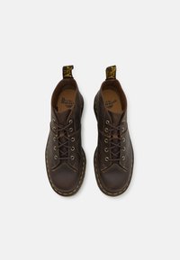 Brune skinn lace-up støvler med gule sømmer og en distinktive trekkstang. Rund tå og polstret krage for komfort.
