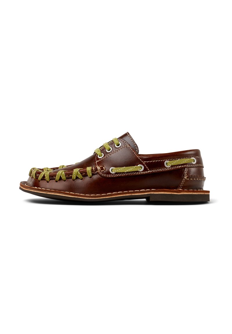 Scarpe slip-on in pelle marrone con lacci e cuciture verdi, caratterizzate da una punta arrotondata, occhielli laterali e una suola piatta.