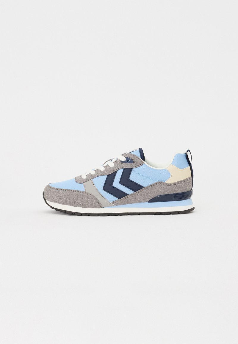 Sport shoe featuring a mix of light blue, grey, and navy materials. Design includes layered panels and a textured sole. White laces and heel tab.