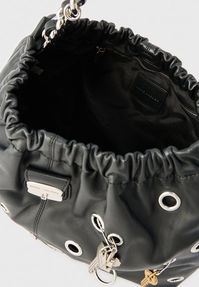 Μαύρη δερμάτινη τσάντα Marc Jacobs με ασημένια μεταλλικά κρίκους, χερούλι με αλυσίδα και μπρελόκ σε σχήμα κλειδιού, ανοιχτή για να αποκαλύπτει εσωτερική τσέπη με φερμουάρ.