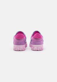 Paire de baskets basses roses et violettes avec semelles texturées et logo GCDS embossé sur les talons, vue de derrière.