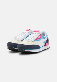 Baskets Puma avec une tige en mesh blanc, des accents en daim bleu clair et bleu marine ; détails roses et turquoise ; semelle en caoutchouc texturée.