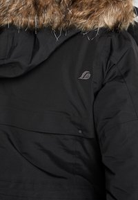 Veste d'hiver noire avec bordure de capuche en fausse fourrure marron et petit logo feuille brodé sur l'épaule droite arrière.