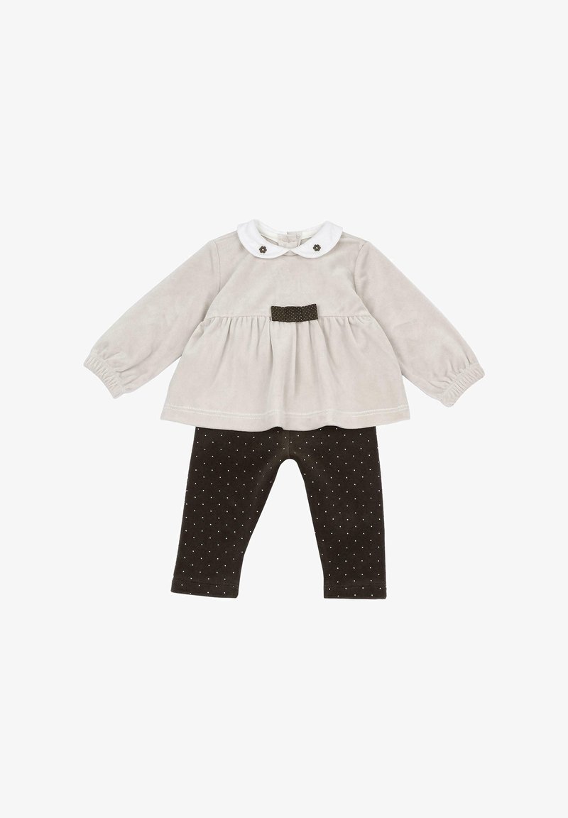 Haut beige à manches longues pour bébé avec col Peter Pan blanc et nœud marron, associé à des leggings marron avec petits pois blancs.