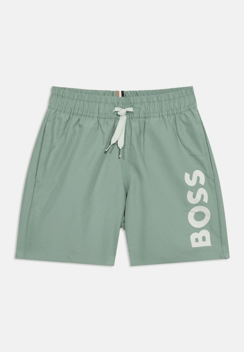 Pantalones cortos de baño verde claro con cinturilla elástica, cordón blanco, bolsillos laterales y texto grande en blanco "BOSS" en la pierna derecha.