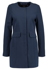 Cappotto lungo blu navy realizzato in tessuto morbido, caratterizzato da un collo rotondo, tasche frontali piatte e una silhouette sartoriale.