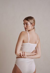 Hvid, letvægts bomulds-camisole med justerbare stropper og en subtil tekstur, parret med matchende højtaljede trusser.