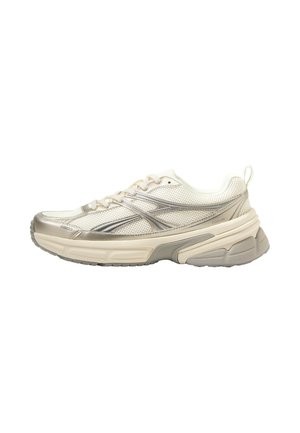 Sneaker atletica crema e beige con tomaia in mesh, strisce decorative argento, suola spessa ammortizzata e tirante sul tallone.