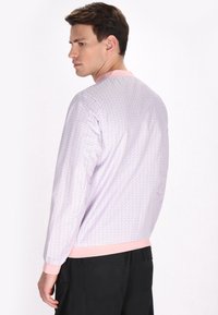 Lichtpaarse sweatshirt met een repetitief patroon, roze kraag en manchetten, lange mouwen en een losse pasvorm, weergegeven vanaf de achterkant.