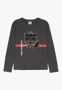 Czarna, szara koszulka z długim rękawem z białym, kreskówkowym kotem w okularach przeciwsłonecznych oraz czerwoną, poziomą linią; "KARL LAGERFELD" nadrukowane wertykalnie.