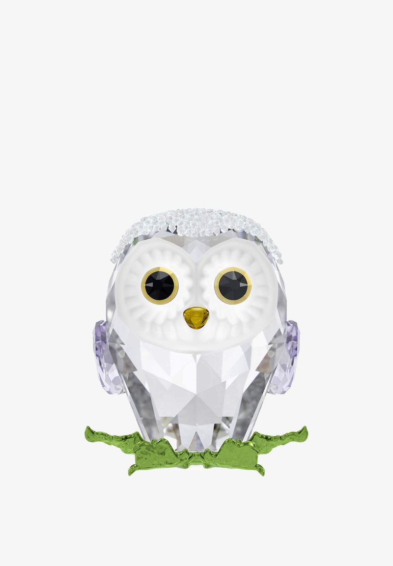 Przezroczysta figurka sowy z dużymi białymi oczami, żółtym dziobem, fioletowymi akcentami na uszach oraz zieloną podstawą przypominającą liście.