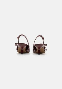 Mauve kiilava nahast slingback kontsad, kitsas konts, dekoratiivne paelaehe ja reguleeritav pahkluu rihm. Sile tekstuur ja läikiv viimistlus.