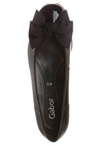 Chaussure plate noire avec une surface en cuir lisse, des bords élastiqués et un grand nœud en tissu décoratif sur l'avant. Dotée d'une semelle intérieure rembourrée.