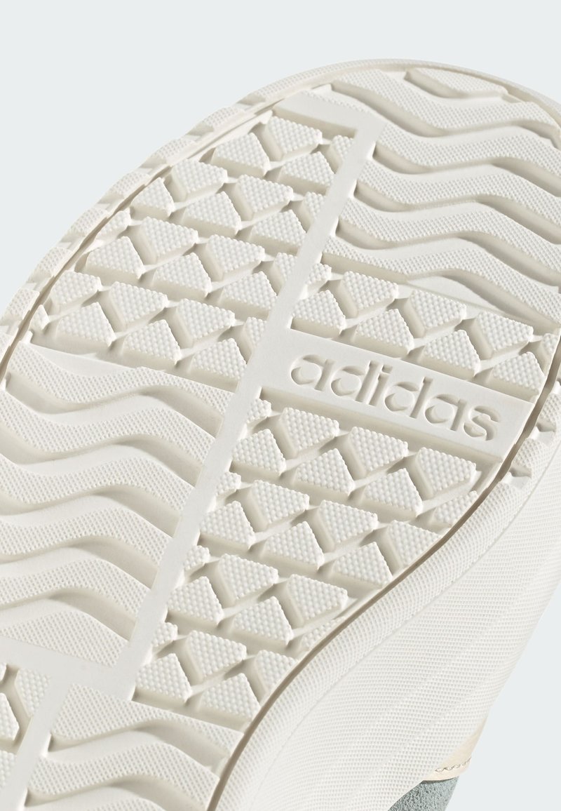 White rubber outsole with a textured pattern of triangles and wavy lines. Features "adidas" logo molded into the rubber.