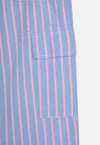 Stripete skjorte i blått og rosa, med en strukturert fabric, stor lomme på venstre side og jevnt fordelte vertikale striper.