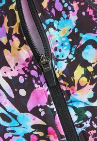 Tissu à motifs multicolores avec des éclaboussures en rose, bleu et jaune. Comprend une fermeture éclair noire avec un tirette YKK au centre.