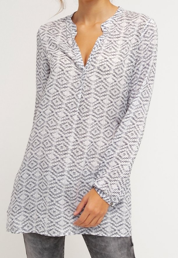 Tunique à manches longues avec un col en V, réalisée en tissu léger présentant un motif géométrique gris et blanc. Texture douce et coupe décontractée.