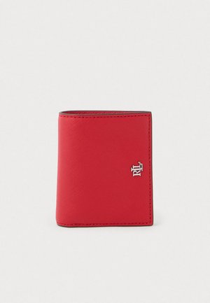 Červená kožená peňaženka s textúrovaným povrchom, s strieborným logom ako akcentom. Obdĺžnikový tvar so šitými okrajmi.