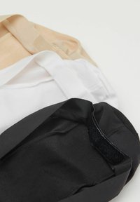 Tres mascarillas de tela en beige, blanco y negro, con suaves correas elásticas y texturas lisas. Cada mascarilla presenta un diseño elegante y sencillo.