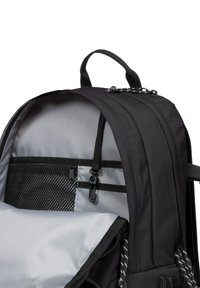 Mochila negra con un interior gris, que cuenta con un bolsillo de malla, cierre de cremallera y tejido texturizado, con un asa y correas ajustables.