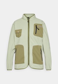 Fleece bunda v svetlozelené farbe s kontrastnými olivovozelenými vreckami, so zipsom a vysokým golierom; obsahuje dve náprsné vrecká a bočné zipsy.