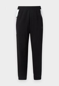Sorte joggers lavet af blødt stof med tapered fit. Har hvide sideskaller, lynlåslommer og elastiske manchetter.