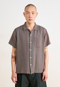 Short-sleeved shirt in multicolored striped fabric, featuring a button-down front and a chest pocket. Smooth texture with a relaxed fit.