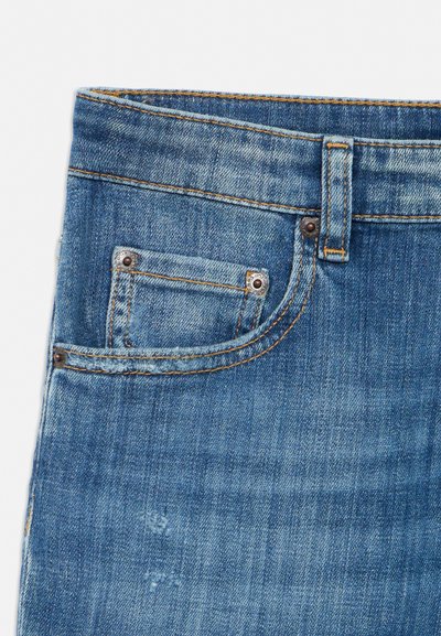 Section de jean en denim bleu montrant la ceinture, la boucle de ceinture, la poche avant avec une petite poche à monnaie et des détails de couture orange visibles.