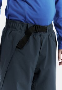 Marina sportbyxor med elastisk midja och ett justerbart svart bälte. Slät, vattenavvisande tyg med sidofickor.