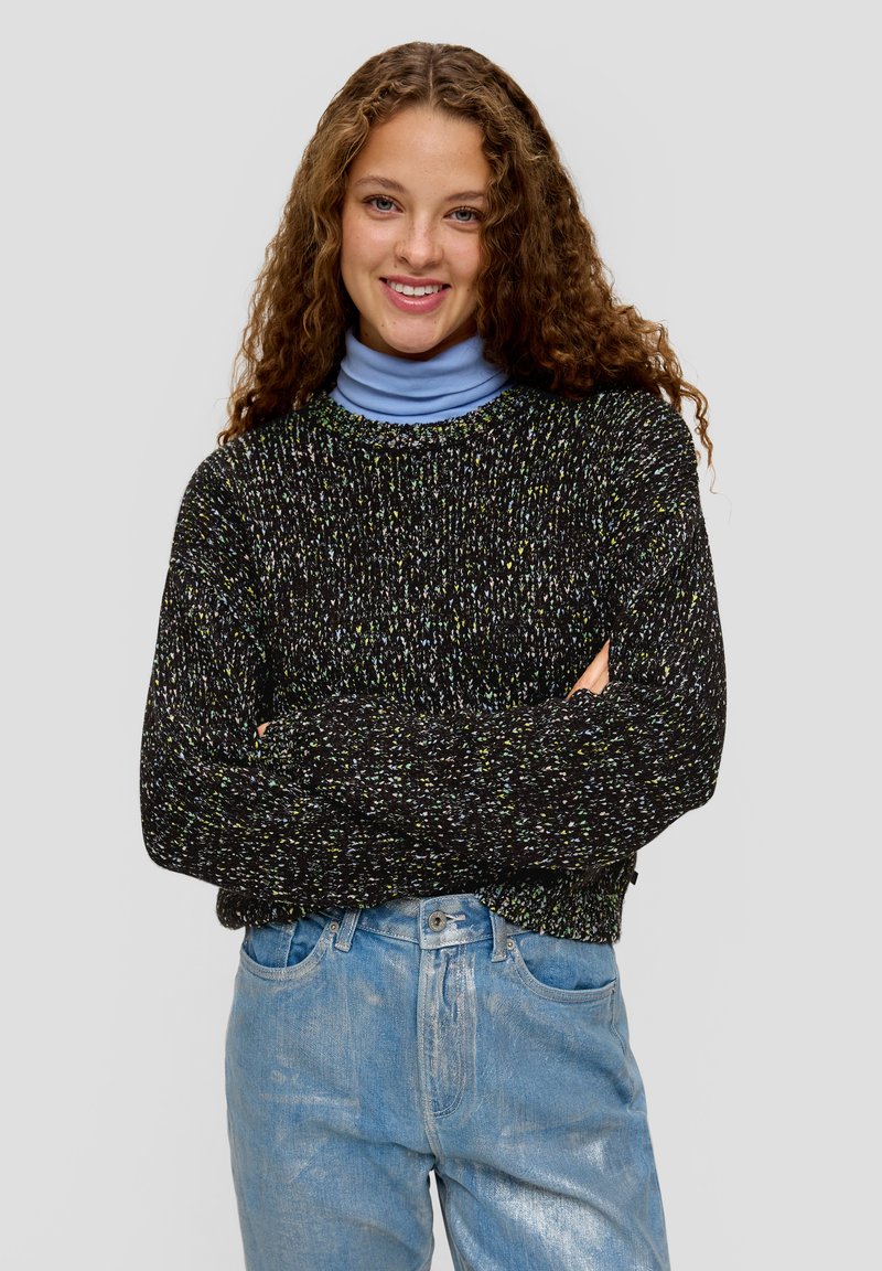 Zwart en multikleurig gebreid sweater met een ronde hals, lange mouwen en een losse pasvorm, gedragen over een lichtblauw turtleneck.