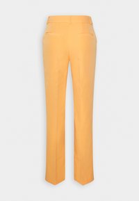 Pantalons ajustés en tissu orange vif. Présentent une coupe droite, deux poches arrière et une texture lisse.