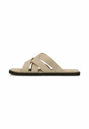 Beige suede flat slide sandal with three wide crisscross straps and black sole on a white background.