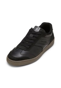 Schwarze Sneakers mit einer Kombination aus glattem und Wildleder, strukturiertem Gummisohle, abgerundeter Zehenpartie und klassischem Schnürdesign.