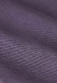 Zacht paars stof met een fijne ribbelstructuur, met zachte plooien en subtiele schaduwen.