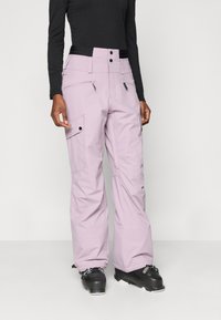 Lyse lilla skibukser med en afslappet pasform, der har flere lommer, lynlåse og en sort talje. Designet til kolde vejrforhold.