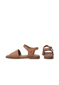 Bruine leren sandalen met een open teen, enkelband en gespafsluiting; platte zool, minimalistisch design en een gladde textuur.