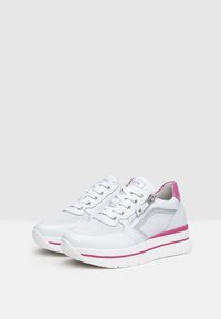 Sneakers bianchi con dettagli rosa e un design testurizzato. Le caratteristiche includono una chiusura con lacci, pannelli in mesh e una suola bianca spessa.