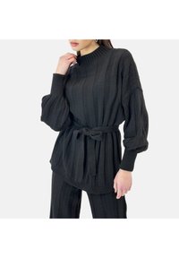Suéter negro de punto con rayas verticales, cuello alto, mangas sueltas y un cinturón atado a la cintura, con puños y dobladillo acanalados.