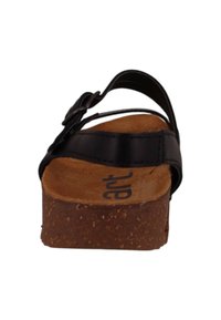 Black leather sandal with a cork footbed, featuring a single strap and adjustable buckle. Thick brown platform outsole.