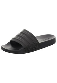 Black slide sandals with a textured strap featuring three raised horizontal lines, sturdy rubber sole, and embossed logo detail on the side.