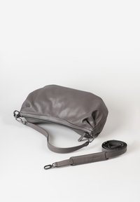 Graue Lederhandtasche mit strukturierter Oberfläche, Reißverschluss und verstellbarem Tragegurt. Mit runder Form und weichem, flexiblem Design.