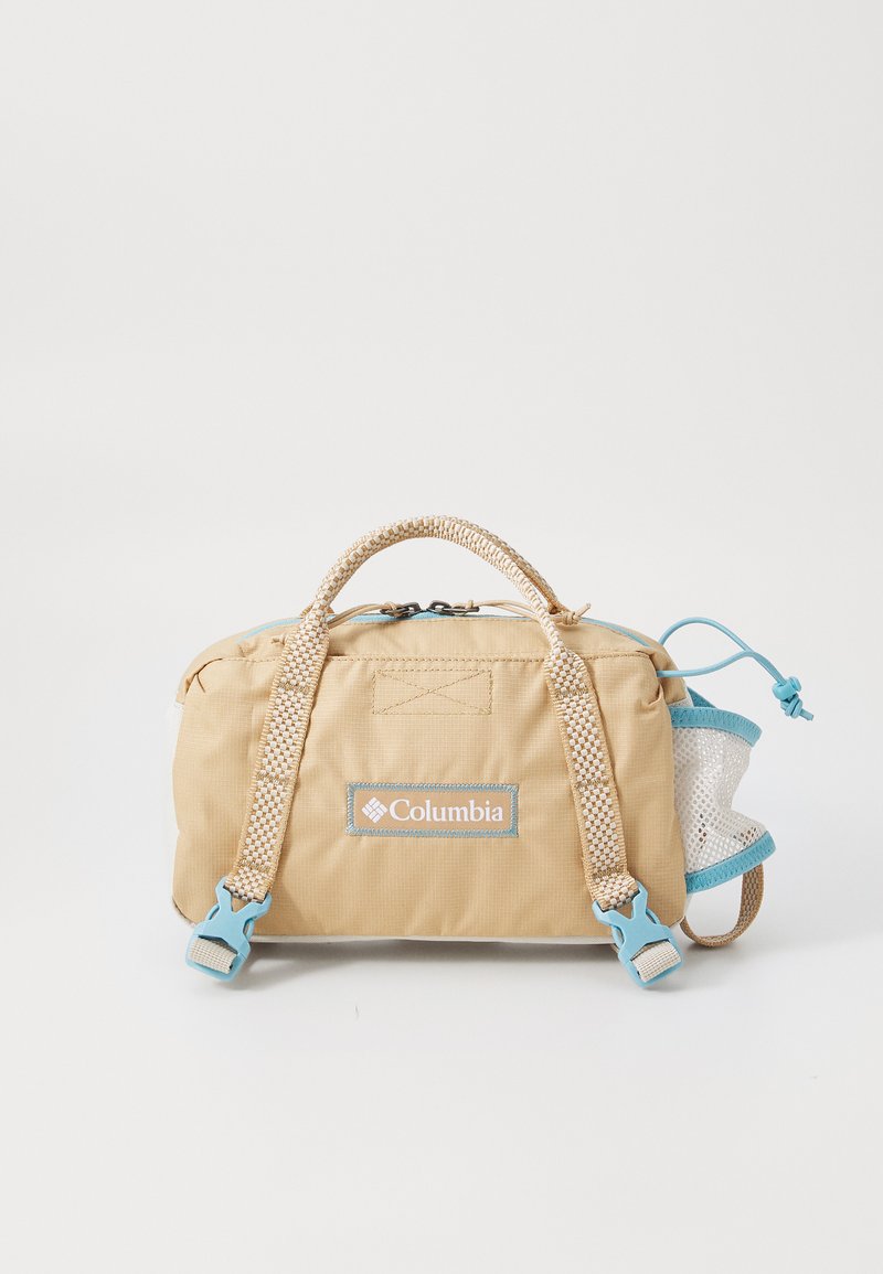 Tote tas van tan stof met gevlochten beige handvatten, blauwe accenten en een zijvak van gaas. Heeft een rits en een logo patch aan de voorkant.